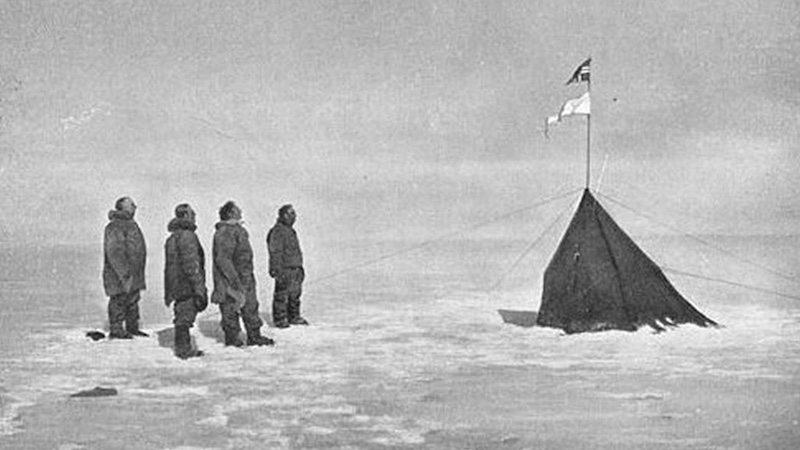 Roald Amundsen and his crew looking at the Norwegian flag at the South Pole, 1911