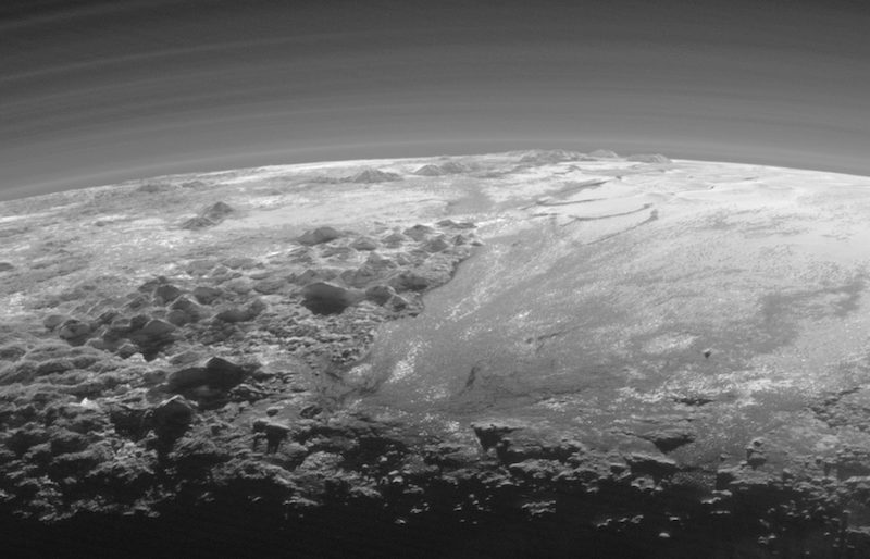 Majestic Mountains and Frozen Plains: Just 15 minutes after its closest approach to Pluto on July 14, 2015, NASA’s New Horizons spacecraft looked back toward the sun and captured this near-sunset view of the rugged, icy mountains and flat ice plains extending to Pluto’s horizon. The smooth expanse of the informally named Sputnik Planum (right) is flanked to the west (left) by rugged mountains up to 11,000 feet (3,500 meters) high, including the informally named Norgay Montes in the foreground and Hillary Montes on the skyline. The backlighting highlights more than a dozen layers of haze in Pluto’s tenuous but distended atmosphere. The image was taken from a distance of 11,000 miles (18,000 kilometers) to Pluto; the scene is 230 miles (380 kilometers) across. Credits: NASA/JHUAPL/SwRI